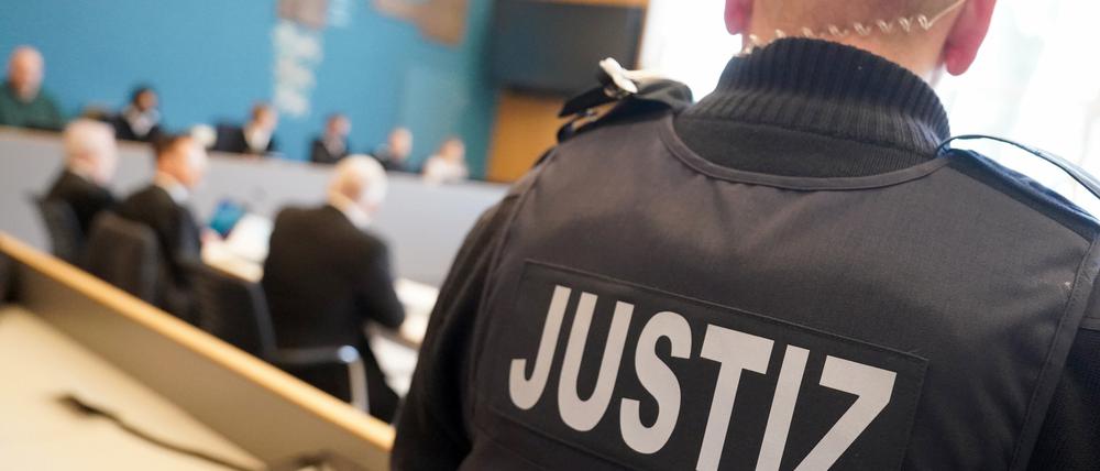Der Angeklagte (3.v.l) sitzt neben seinen Anwälten vor Beginn des Prozesses wegen schweren sexuellen Missbrauchs eines Kindes im Sitzungssaal im Landgericht Lübeck. 