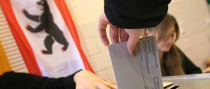 Eine Frau gibt ihre Stimme für die Wahl zum Berliner Abgeordnetenhaus ab und wirft ihren Wahlzettel in die Wahlurne.