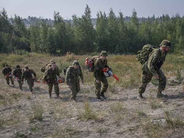 Soldaten der kanadischen Streitkräfte gehen in den Wald, um eine Feuerschneise hinter dem Parker Recreation Field in Yellowknife zu errichten.