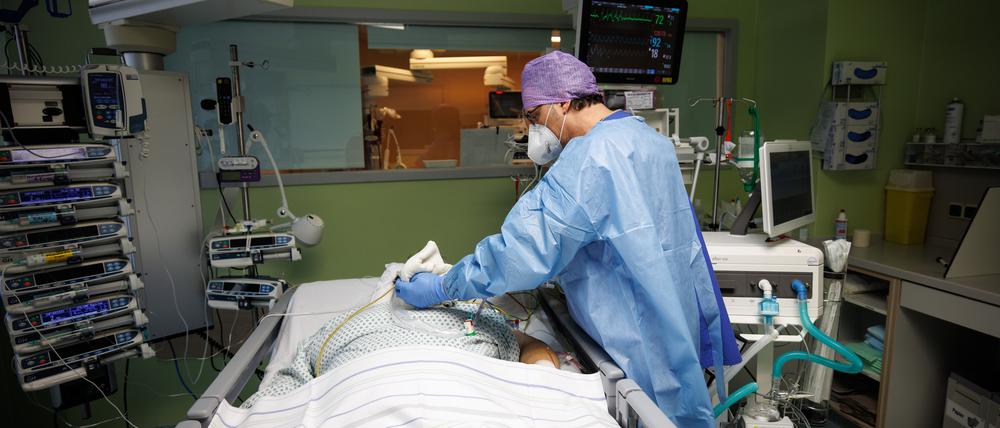 Lorenz Nowak, Chefarzt der Klinik für Intensivmedizin, arbeitet in Schutzkleidung in einem Intensivbett-Zimmer in der Asklepios Klinik am Bett eines über einen Luftröhrenschnitt beatmeten Corona-Patienten.