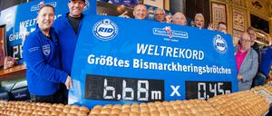 Axel Schulz, ehemaliger Profiboxer (2.v.r), André Domke (1.v.r), Fischsommelier und Fischhändler stehen am Weltrekord.