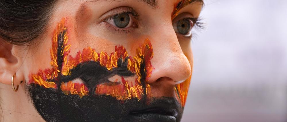 Eine Demonstrantin mit einem Bild im Gesicht, das ein Känguru zeigt, das vor dem Feuer wegläuft, nimmt 2020 an einem Protest gegen die Klimapolitik vor der australischen Botschaft in Buenos Aires teil.