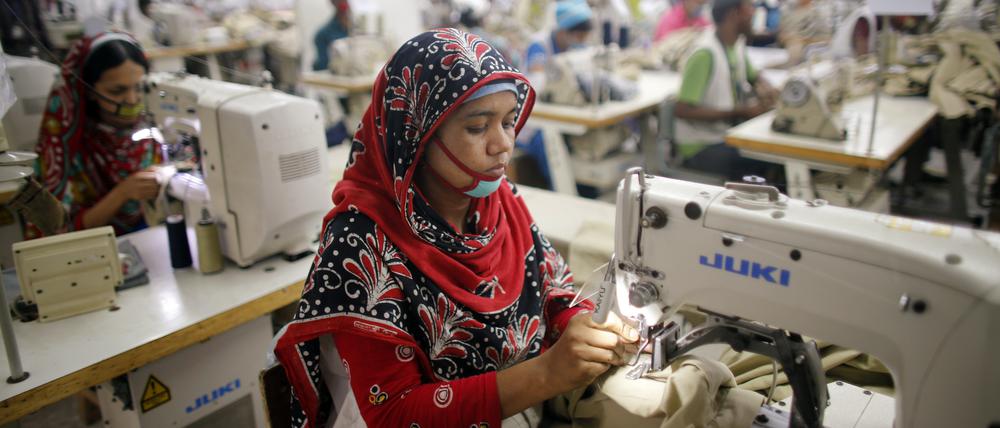 Arbeiterin in eine Textilfabrik beim Nähen an einer Nähmaschine. (Symbolbild)