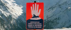 Ein Schild warnt in einem Skigebiet in den Alpen vor Lawinengefahr.