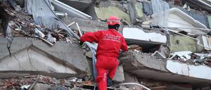 Ein Retter sucht nach Überlebenden auf den Trümmern eines Gebäudes. 