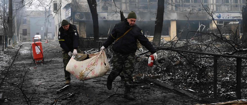 Nach einem russischen Raketenangriff transportieren Polizisten in Kiew einen Toten ab.