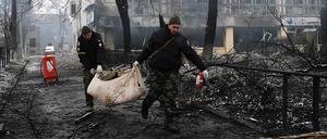 Nach einem russischen Raketenangriff transportieren Polizisten in Kiew einen Toten ab.