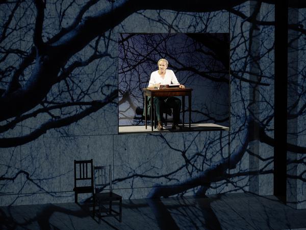 Paul Herwig am schwebenden Schreibtisch inmitten der Mondschein-Bühnenprojektion