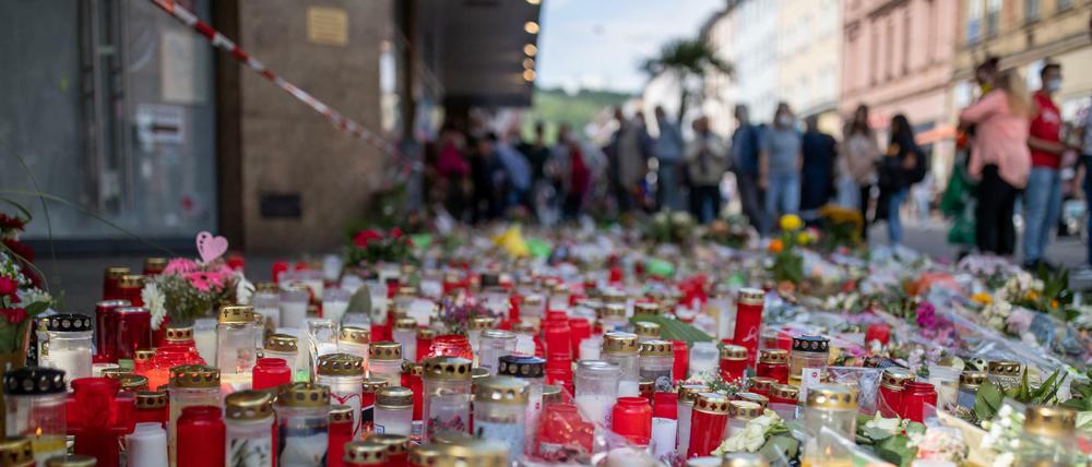Grablichter, Kerzen und Blumen liegen vor einem Kaufhaus in der Innenstadt von Würzburg.