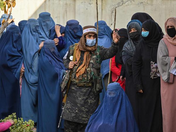 Kabul, November 2021: Ein Taliban-Kämpfer bewacht die Schlange vor einer Ausgabestelle des UN-Welternährungsprogramms.