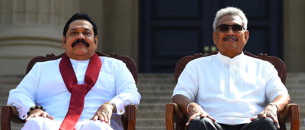 (FILES) In this file photo taken on November 22, 2019, Sri Lanka's new President Gotabaya Rajapaksa (R) and his Prime Minister brother Mahinda Rajapaksa, pose for a group photograph after the ministerial swearing-in ceremony in Colombo. - Millions of rupees in cash left behind by President Gotabaya Rajapaksa when he fled his official residence in the capital will be handed over to court on July 11, 2022, police said. (Photo by ISHARA S. KODIKARA / AFP)