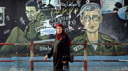 Eine Palästinenserin läuft im Gazastreifen an einem Wandbild des gefangenen israelischen Soldaten Gilad Schalit vorbei.