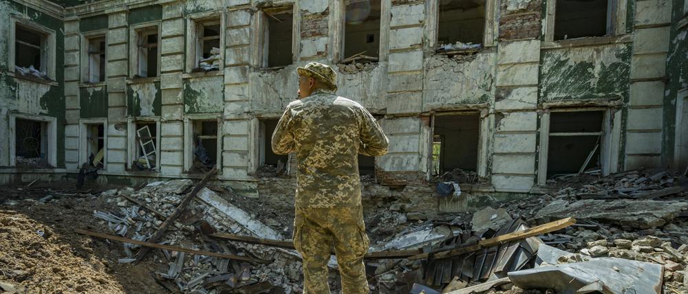Ukrainischer Soldat vor einer bombardierten Schule in der Region Donbass.
