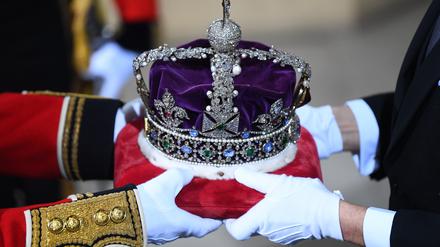 Die Krone wird im Eingang für die Monarchin zum britischen Oberhaus im Westminsterpalast anlässlich der feierlichen Wiedereröffnung des britischen Parlaments übergeben. 