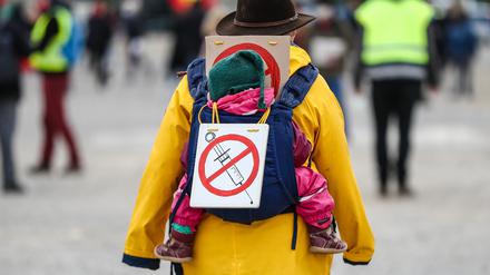 Eine Teilnehmerin einer Protestkundgebung der Initiative „Querdenken“ trägt auf dem Cannstatter Wasen ein Schild gegen Impfungen auf ihrem Rücken. 