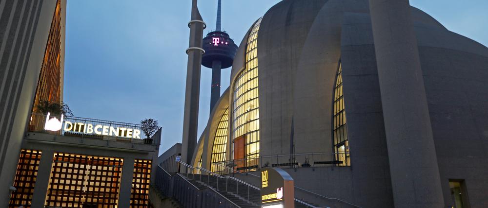 Die Ditib Moschee in Köln-Ehrenfeld ist am Morgen beleuchtet, dahinter ist der Kölner Fernsehturm (M) zu sehen. Am Mittwoch (03.03.2021) beraten Bund und Länder über ihr weiteres Vorgehen in der Corona-Krise. +++ dpa-Bildfunk +++