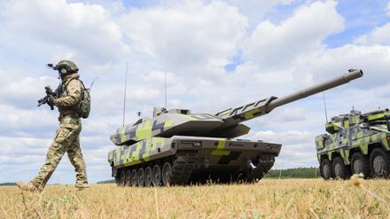 Ein „Infanterist der Zukunft“ steht neben einem Kampfpanzer Panther KF51 des Rüstungskonzerns Rheinmetall.