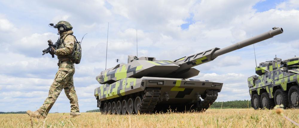Ein „Infanterist der Zukunft“ steht neben einem Kampfpanzer Panther KF51 des Rüstungskonzerns Rheinmetall.