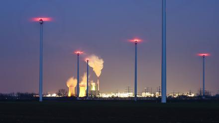 Der Schornstein und die Kühltürme des Braunkohlekraftwerks Schkopau dampfen hinter einem Windpark. Die kriegerischen Auseinandersetzungen lassen in Deutschland die Diskussion um den Ausstieg aus der Braunkohle und den Ausbau der Erneuerbaren Energien wieder aufleben. 
