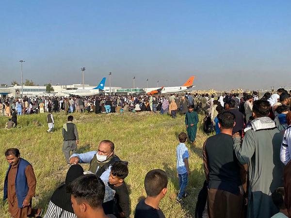 Hunderte Afghanen warten am Rande des Flughafens von Kabul. 