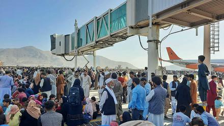 Wartende auf der Start- und Landebahn des Kabuler Flughafens im August 2021. Die Machtübernahme der Taliban hatte zahlreiche Menschen in Afghanistan in die Flucht geschlagen.