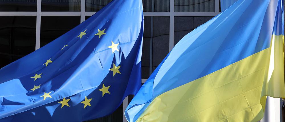 The Ukrainian flag flutters along side the European Union flag outside the European Parliament headquarters to show their support for Ukrania after the nation was invaded on February 24 by Russia, in Brussels on February 28, 2022. (Photo by François WALSCHAERTS / AFP)
