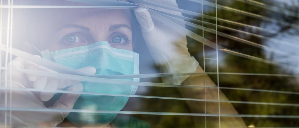 Concerned Healthcare worker looking through a window