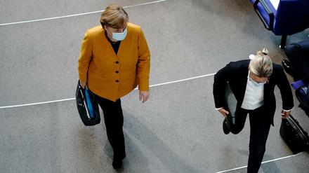 Bundeskanzlerin Angela Merkel (l, CDU) verlässt ihren Platz neben Alice Weidel, Fraktionsvorsitzende der AfD, nachdem sie im Bundestag bei der Regierungsbefragung die Fragen der Bundestagsabgeordneten beantwortet hat. Ein Hauptthema sind die Oster- und Lockdown-Beschlüsse der Bund-Länder-Konferenz zu der Corona-Pandemie. 