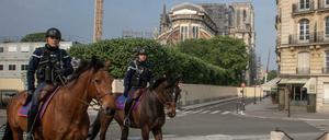 Berittene Polizisten patrouillieren neben der Kathedrale Notre Dame. 