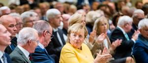 Angela Merkel (CDU), ehemalige Bundeskanzlerin, applaudiert neben Friedrich Merz.