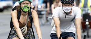 Teilnehmer einer Fahrraddemo tragen zum Schutz vor dem Coronavirus eine Maske. 