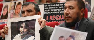 Mitglieder der muslimischen uigurischen Minderheit zeigen während einer Pressekonferenz in Istanbul Bilder ihrer in China inhaftierten Angehörigen. 