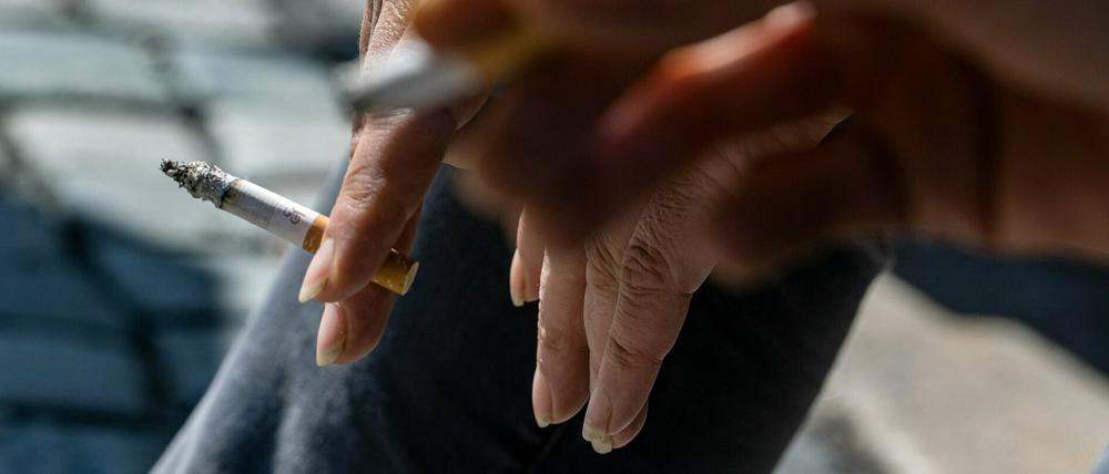 Raucher halten eine brennende Zigarette in der Hand. Der Verbrennungsprozess fördert krebserregende Stoffe zutage.