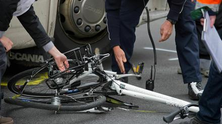 Polizisten und Gutachter bergen am in Berlin ein zertrümmertes Fahrrad unter einem Lkw nach einem Unfall (Archivbild vom 25.04.2012).