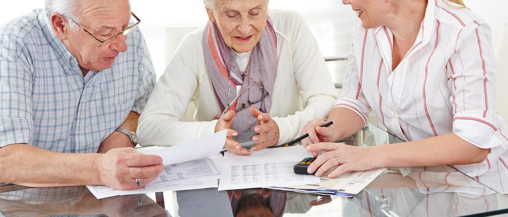 Ein Paar Senioren bekommt Beratung zu Finanzthemen am Tisch