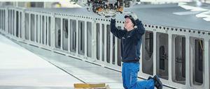 Fachkräfte in Sorge. Eine Airbus-Mitarbeiterin im niedersächsischen Stade arbeitet an einem Industrieroboter, der Tragflächen für den Airbus A350 herstellt. Foto: Axel Heimken/dpa