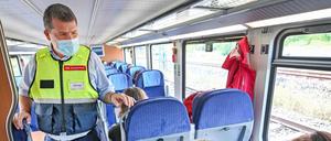 Ein Team der Deutschen Bahn kontrolliert in einem Zug das Tragen von Mund-Nasen-Bedeckungen bei den Fahrgästen. (Archiv)