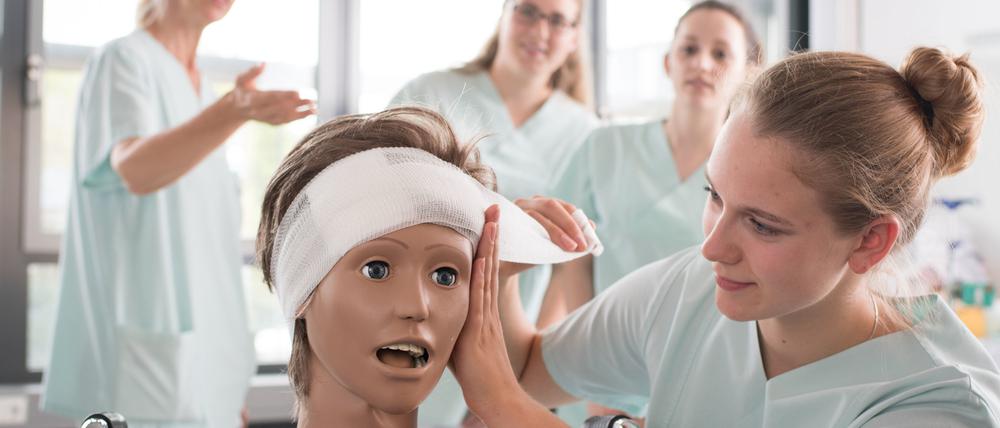 Pflegeschülerinnen lernen das Anlegen eines Kopfverbandes im Klinikum Stuttgart. 