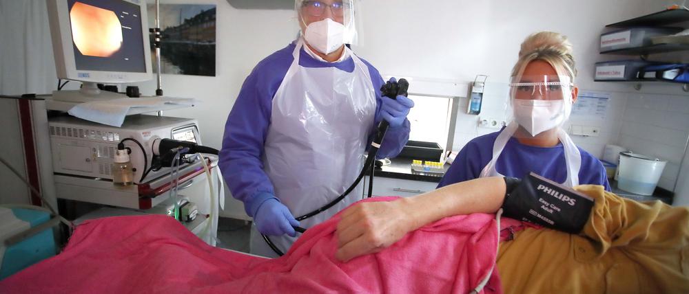 Andreas Schroeder, Gastroenterologe, bei einer ambulanten Vorsorgekoloskopie mit Coronahygiene-Massnahmen in Schutzkleidung bei einer Darmspiegelung, in seiner Praxis in Berlin.