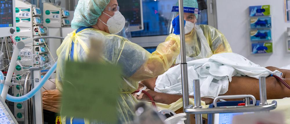 Ein Patient wird auf der Covid-19-Intensivstation des Klinikum „Rechts der Isar“ von Fachkräften medizinisch betreut.