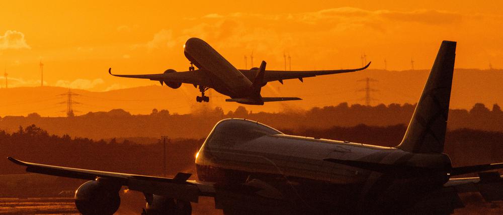 Ein Flugzeug startet im letzten Licht der Sonne am Flughafen Frankfurt.