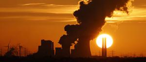 Das Kohlekraftwerk Niederaußem in Nordrhein-Westfalen zeichnet sich gegen die untergehende Sonne ab.