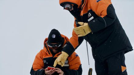 Alex Aves (l.) von der Canterbury University notiert Daten während der Probennahme von Schnee in der Antarktis. 