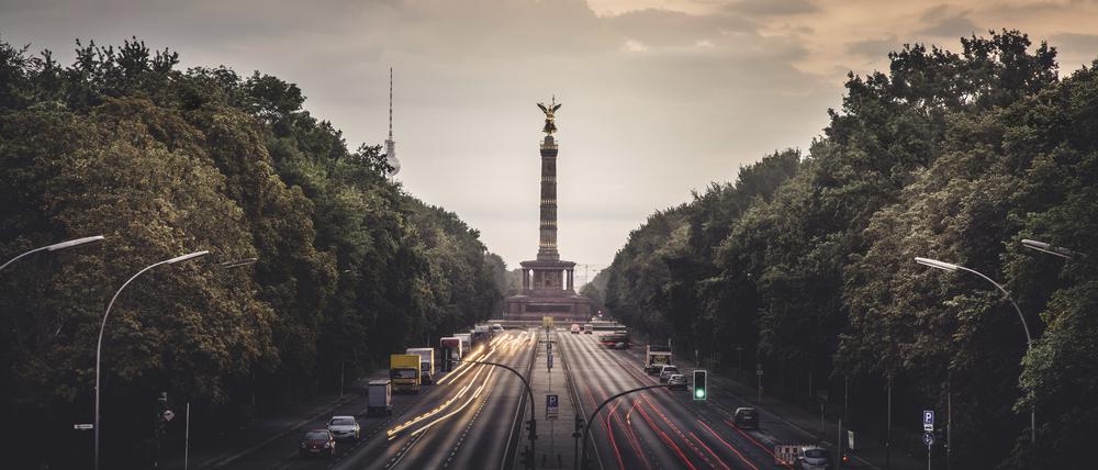 Morgenrot hinter der Straße des 17. Juni mit Siegessäule und Fernsehturm in Berlin.